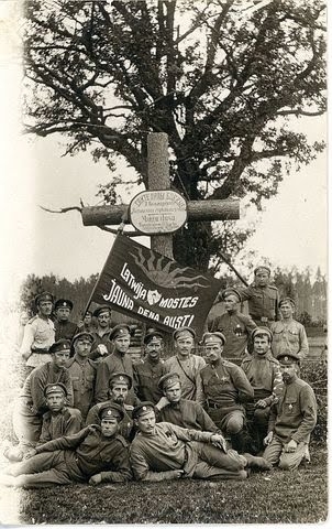 8. Valmieras latviešu strēlnieku pulks pie kritušo biedru kapa Ložmetējkalna apkārtnē 1917.gada vasarā ar uzrakstu - Latvija, mosties - jauna diena aust- uz karoga.